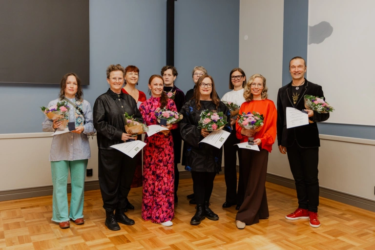 Palkinnonsaajat kukkakimppujen kanssa Oulun kaupungintalolla.