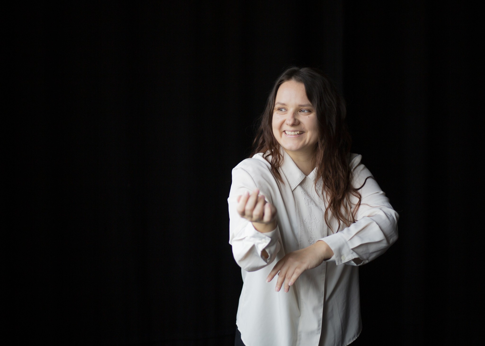 Rebecca Laube-Pohto hymyilee, yllään valkoinen kauluspaita.