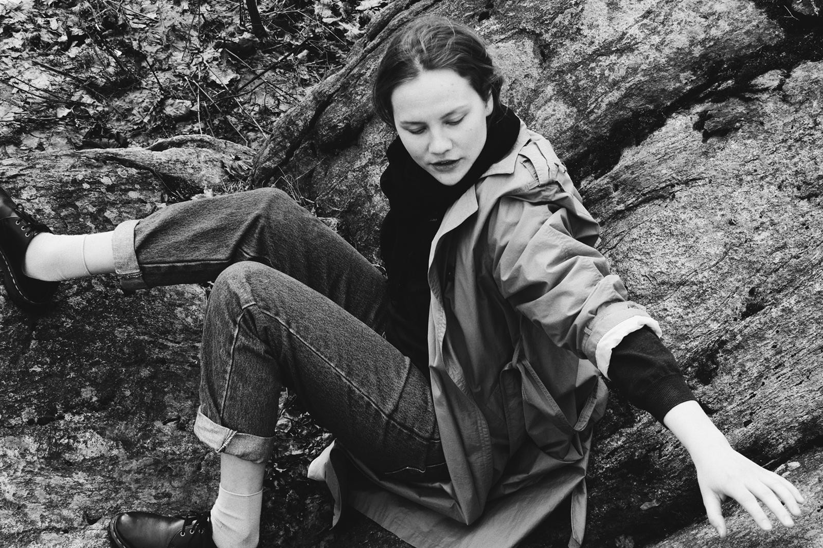 Sofia Keto-Tokoi farkut ja ulkoilutakki yllään kallioisessa maastossa istumassa.